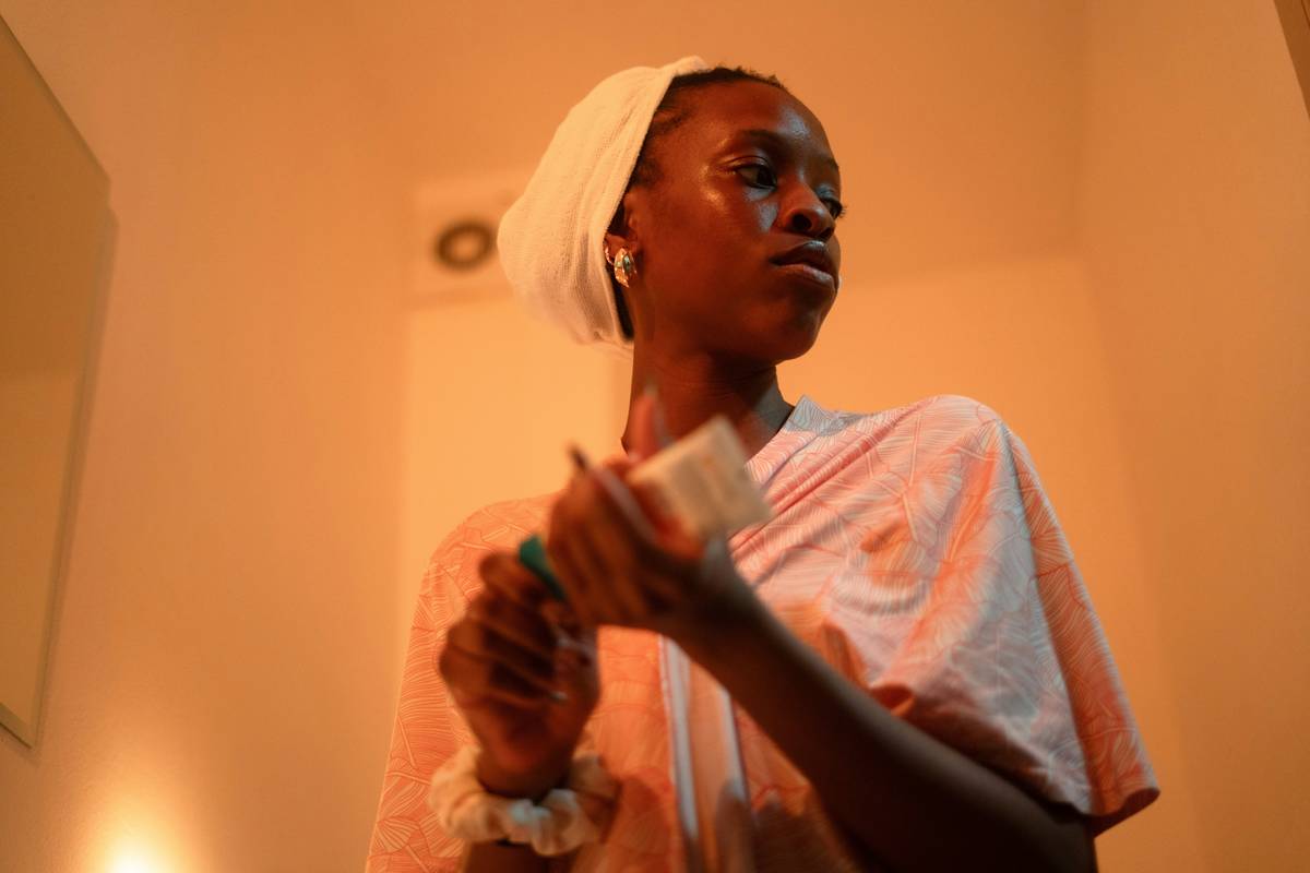 woman applying dickinson s witch hazel astringent with cotton pad on clean skin