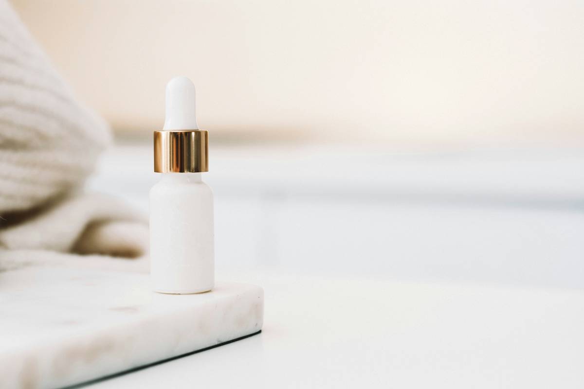witch hazel for acne breakouts applied with cotton pad on clear skin